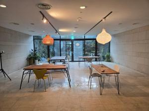 a dining room with tables and chairs and lights at Hallasan Resort in Sanch'ŏndan