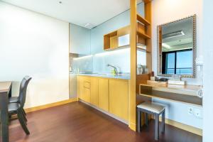 a kitchen with a sink and a table and a mirror at Hallasan Resort in Sanch'ŏndan