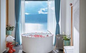 a bath tub in a room with a large window at Nanshe Nan Inn Dali in Dali Airport +56 photos