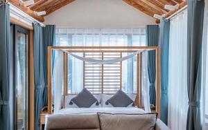 a bedroom with a bed and a large window at Nanshe Nan Inn Dali in Dali Airport