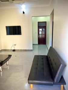 een zwarte bank in een kamer met een tv bij home in Nungwi