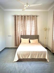 een slaapkamer met een groot bed voor een raam bij home in Nungwi