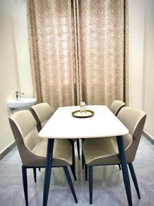 een witte tafel en stoelen in een kamer bij home in Nungwi