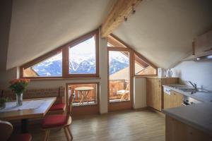 a kitchen with a table and a view of a mountain at Schuistlhof in Sillian