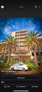 a car driving in front of a building with palm trees at Wynn hotel in Bahir Dar