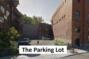 a parking lot next to a brick building with the words the parking lot at FREE PARKING - 5 minute walk to METRO STATION Berri Uqam - In-Suite WASHER & DRYER - fully stocked KITCHEN - WORKSPACE PROVIDED - FAST WIFI in Montréal