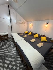 een groot bed in een kamer met gele kussens bij Lacto Cressida in Palolem