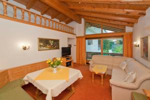 ein Wohnzimmer mit einem Sofa und einem Tisch in der Unterkunft Haus Waldrand in Oberndorf in Tirol