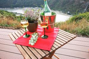 ザンクト・ゴアールスハウゼンにあるLoreley Hillsのワインとブドウのグラス2杯付きテーブル