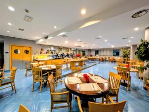 a restaurant with tables and chairs and a cafeteria at Hotel Express Aosta East in Aosta