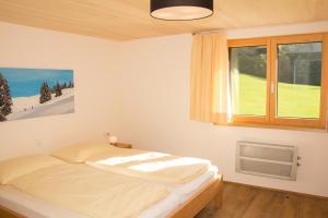 una camera con letto e finestra di Haus Feurstein a Hittisau