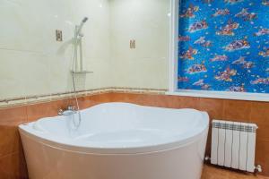 スタヴロポリにあるHotel VITAのバスルーム(トイレ付)が備わります。壁に絵画が飾られています。