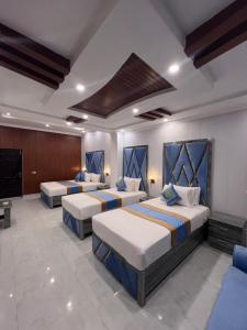 a room with three beds and a television at Gulberg Residency Hotel in Lahore +57 photos