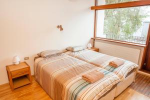 two beds in a bedroom with a window at Cozy 60's villa in Reykjavik in Reykjavík