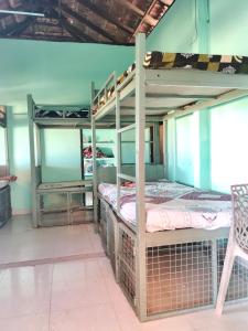 a room with two bunk beds with a chair at Birdwatching and kaya king for backpackers in Alleppey