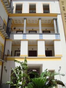 ein weißes Gebäude mit blau und gelb verzierten Wänden in der Unterkunft Appartamento Alloro 2 in Palermo