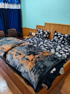 a bed with a comforter on top of it at Apple Zone Home stay in Banjār