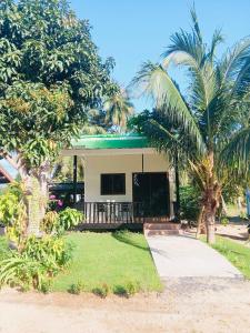 a house with palm trees in front of it at First Light Garden House in Koh Phangan