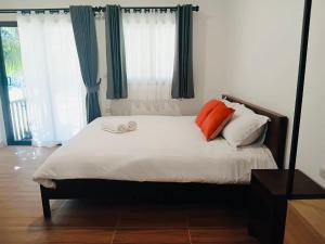a bedroom with a bed with two orange pillows at First Light Garden House in Koh Phangan