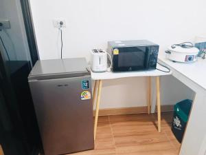 a microwave sitting on a table next to a refrigerator at First Light Garden House in Koh Phangan +3 photos