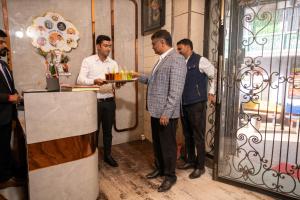 un groupe d'hommes debout autour d'un bar avec un plateau de nourriture dans l'établissement Namaste Khatu Shyam, à Khātu