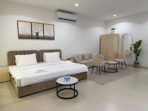 een slaapkamer met een bed, een bank en tafels bij Sky5 Apartment in Hatta