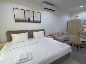een slaapkamer met een groot bed en een stoel bij Sky5 Apartment in Hatta +3 foto's