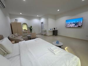 een slaapkamer met een wit bed en een woonkamer bij Sky5 Apartment in Hatta