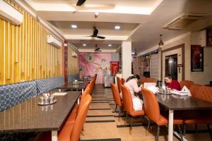 two people sitting at tables in a restaurant at Hotel Sawamani - 100 Meters from Khatushyam ji in Khātu