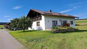 una casa bianca con un albero e un prato di Ferienwohnung Wenzl a Zandt