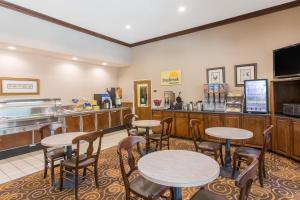 a restaurant with tables and chairs and a counter at Days Inn by Wyndham Lexington in Lexington