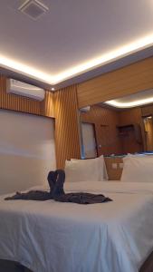 een groot wit bed in een hotelkamer bij 7 Day Inn in Gili Trawangan