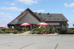 a restaurant with red umbrellas in front of a building at Gościniec Legenda in Wyszogród