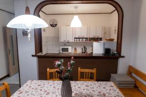 a kitchen with a table with a vase of flowers on it at Farma Basarovi in Prosečné