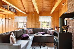 een woonkamer met een bank en een open haard bij VGO786-Hacksvik-Hacksvik-1 in Bygärde