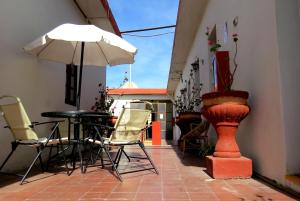 a patio with a table and chairs and an umbrella at Gran Hotel in Arequipa
