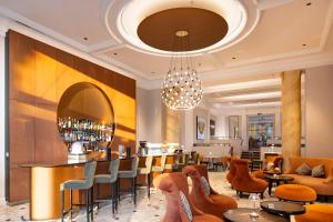 a restaurant with a bar with chairs and tables at Hôtel de la Paix Lausanne in Lausanne