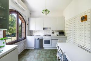 a kitchen with white cabinets and white appliances at Daller Bianca by Whale Homes in Soiano del Lago