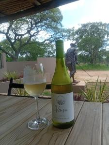 a bottle of wine and a glass on a table at Sasavona Boutique Hotel in Polokwane