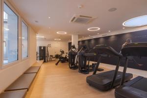a gym with treadmills and ellipticals in a room at Hôtel de la Paix Lausanne in Lausanne