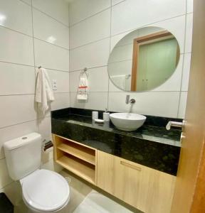 a bathroom with a toilet and a sink and a mirror at Studio Praia de Carneiros in Praia dos Carneiros +4 photos