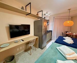 a room with a television and a desk with a tv at Studio Praia de Carneiros in Praia dos Carneiros