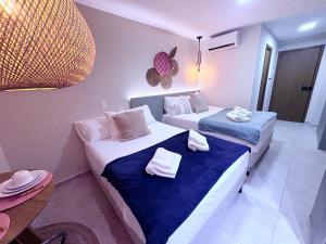 a hotel room with two beds and a table at Studio Praia de Carneiros in Praia dos Carneiros