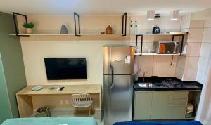 a small kitchen with a stainless steel refrigerator and a desk at Studio Praia de Carneiros in Praia dos Carneiros