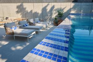 a swimming pool with lounge chairs and a swimming pool at WorldHotels Guadalajara Zona Andares in Guadalajara