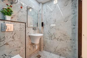 ニューデリーにあるHotel The Olive Aero Suites Near Delhi Airportの洗面台とガラスのシャワーを備えたバスルーム
