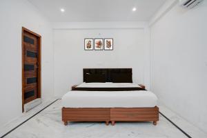 a bedroom with a bed in a white room at Hotel O The Skyrise Lucknow Hotel in Lucknow