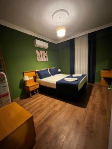 a bedroom with a bed and a green wall at Nehir Apart Hotel in Fethiye