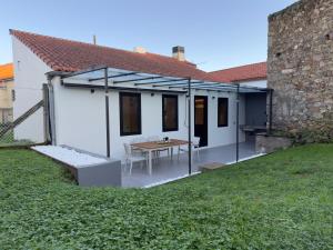 a white house with a table in a yard at Casa Gafura in Noya