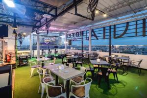 un restaurant avec des tables et des chaises et une vue sur la ville dans l'établissement NIVIA HOTEL, à Pulauberayan Dadap